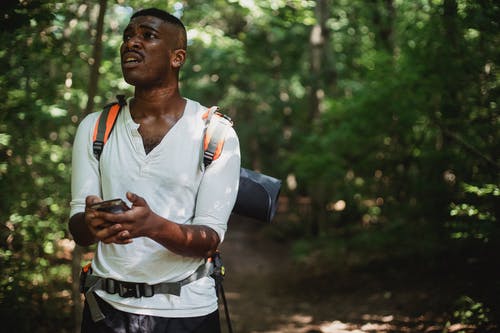 黑人与智能手机在森林里迷路了 · 免费素材图片