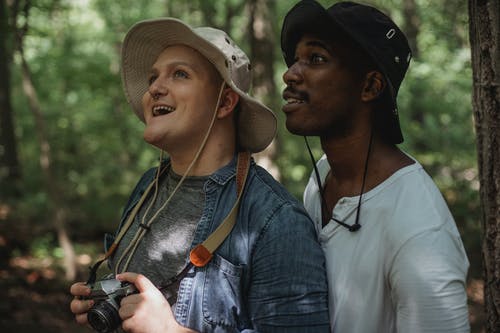 站在森林里的惊讶多民族男性朋友徒步旅行者 · 免费素材图片