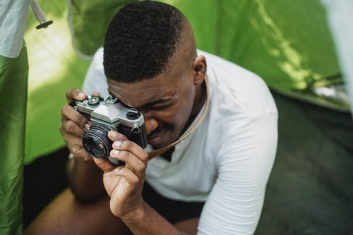 黑人男性的徒步旅行者在复古相机拍照 · 免费素材图片