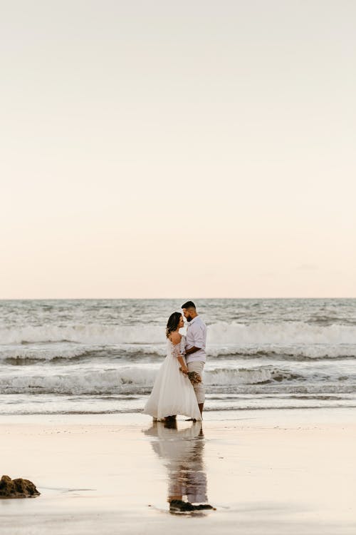 婚礼后无法识别浪漫情侣拥抱在沙滩上 · 免费素材图片