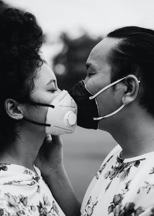 情侣面罩接吻的灰度照片 · 免费素材图片
