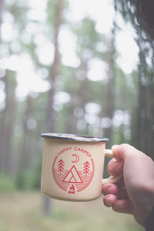 拿着白色和红色陶瓷杯的人 · 免费素材图片