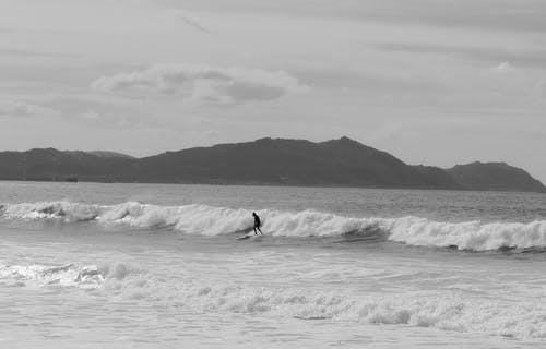 孤独的冲浪者在波涛汹涌的海上骑波 · 免费素材图片