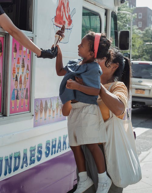 族裔女人带着女儿买冰淇淋 · 免费素材图片