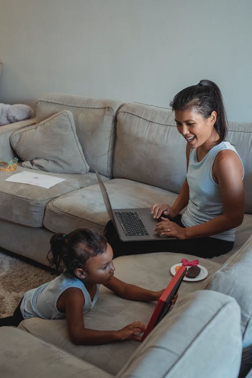 有看女儿的膝上型计算机的种族妇女 · 免费素材图片