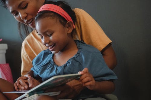 积极作物亚洲母亲带着女儿看书 · 免费素材图片
