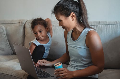 母亲和女儿看着笔记本电脑 · 免费素材图片