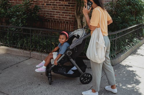 族裔母亲和女儿在大街上行走 · 免费素材图片