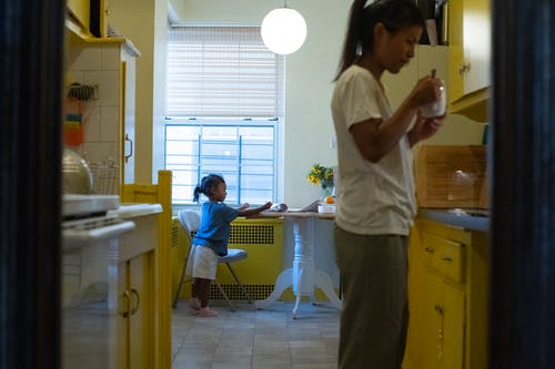 亚洲母亲带着女儿在厨房里喝咖啡 · 免费素材图片