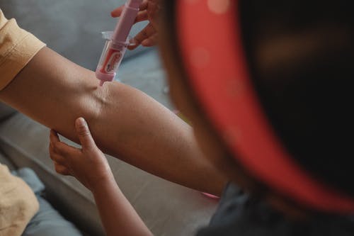播种族裔女儿用玩具注射器注射母亲 · 免费素材图片