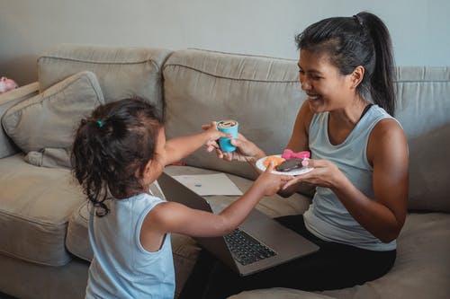 开朗的妈妈和女儿用玩具糖果 · 免费素材图片