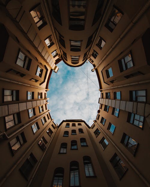蓝蓝的天空下的棕色混凝土建筑的低角度摄影 · 免费素材图片