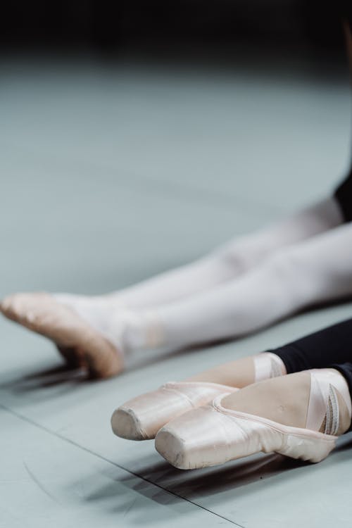 作物芭蕾舞演员在日间训练期间伸展脚 · 免费素材图片