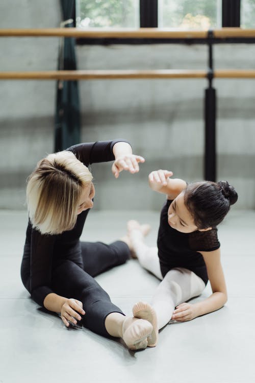 冷静与芭蕾舞教练在工作室里锻炼的女孩 · 免费素材图片