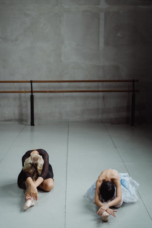 伸展身体的芭蕾舞演员在演播室 · 免费素材图片