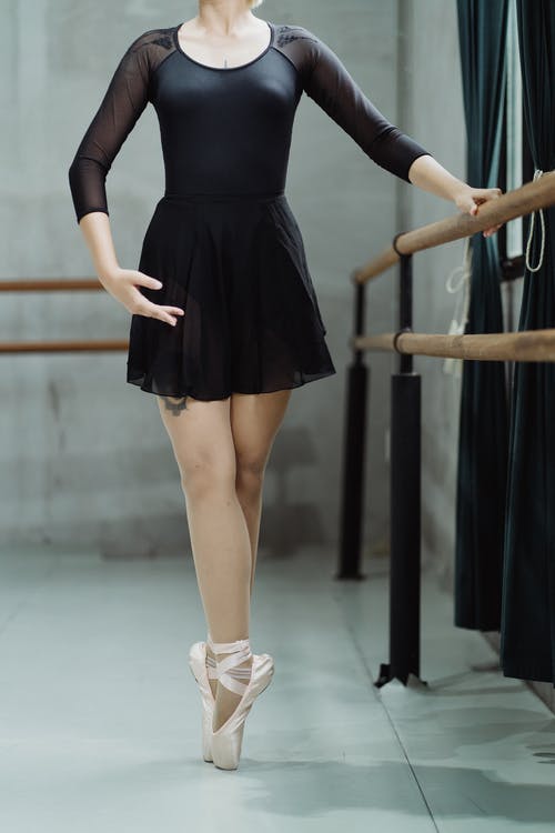 裁剪不露面芭蕾舞女演员tip脚站在工作室附近铁路 · 免费素材图片