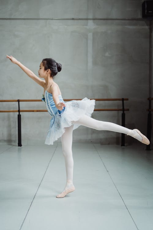 芭蕾舞女演员在芭蕾舞工作室伸展身体 · 免费素材图片