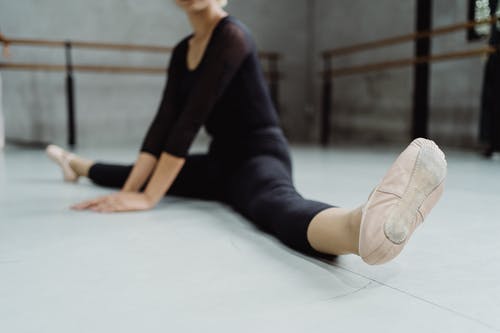芭蕾舞演员在宽敞的工作室练习拆分 · 免费素材图片