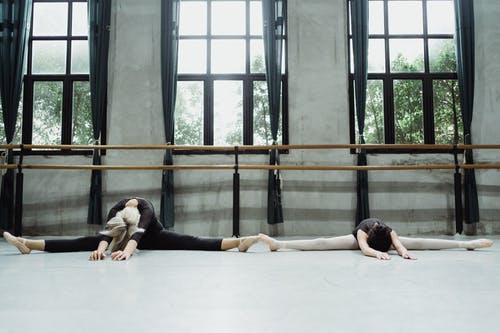 不露面的芭蕾舞演员做分裂并向后伸展 · 免费素材图片