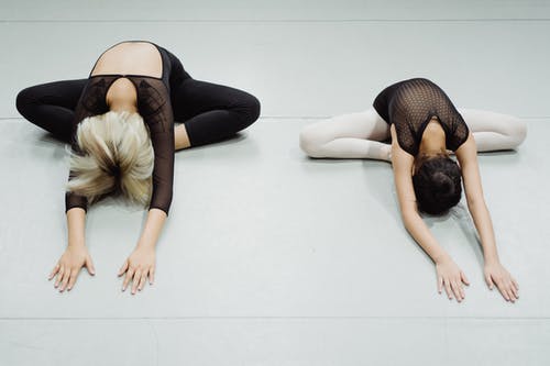 匿名的年轻女舞者训练前提高灵活性 · 免费素材图片