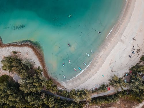 绿松石海洋与船和沙质海岸 · 免费素材图片