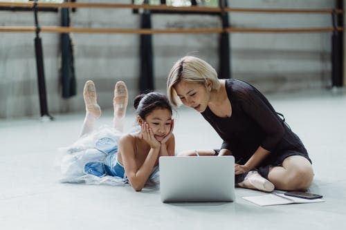 有使用膝上型计算机的个人辅导员的亚裔女孩在芭蕾演播室 · 免费素材图片