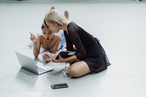 与教练使用笔记本电脑打动亚洲小芭蕾舞演员 · 免费素材图片