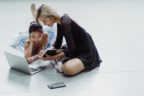性格开朗的亚洲女孩和女人在舞厅里使用笔记本电脑 · 免费素材图片