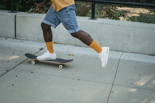 黑人男子骑滑板街 · 免费素材图片
