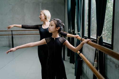 亚洲学生与教练练习芭蕾附近的芭蕾 · 免费素材图片