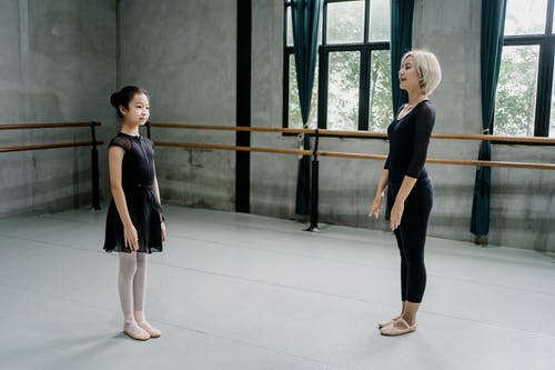 芭蕾舞女演员教练和女孩实习生站在工作室 · 免费素材图片