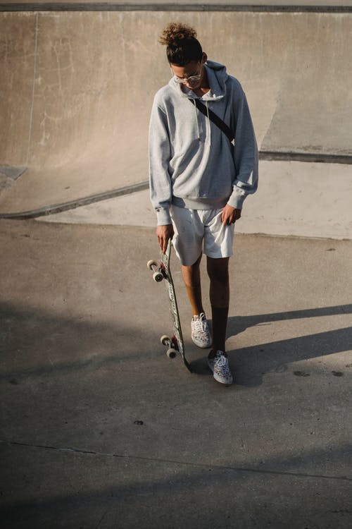 滑板沿着混凝土坡道走的年轻选手 · 免费素材图片