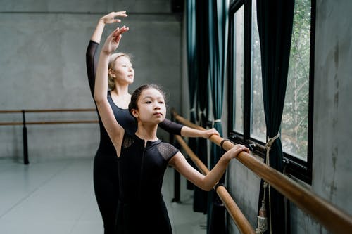 苗条的亚洲芭蕾舞演员在工作室里举手近杠铃 · 免费素材图片