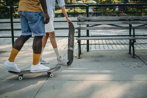 多种族的朋友在白天在大街上骑滑板 · 免费素材图片