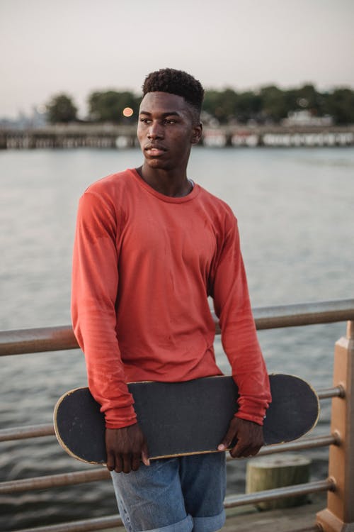 滑板在路堤上的黑人男子 · 免费素材图片