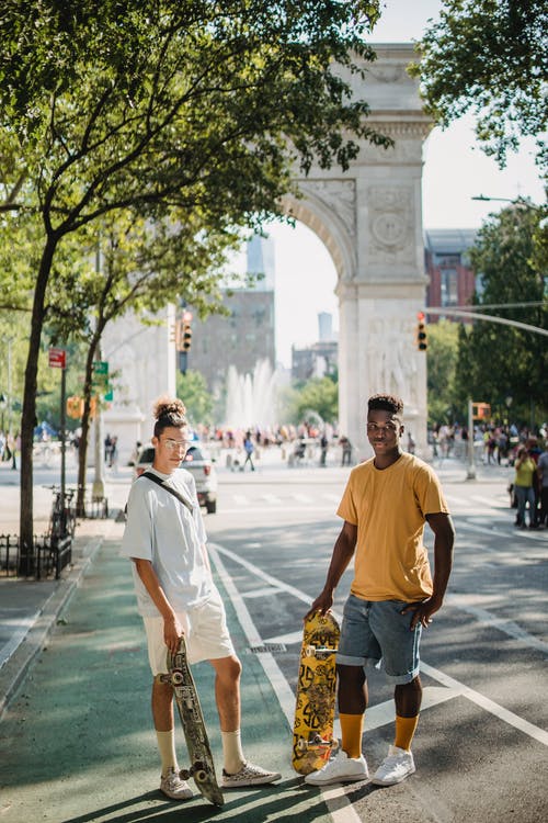 适合年轻多样的男性朋友，站在大街上凯旋门附近在阳光灿烂的日子 · 免费素材图片