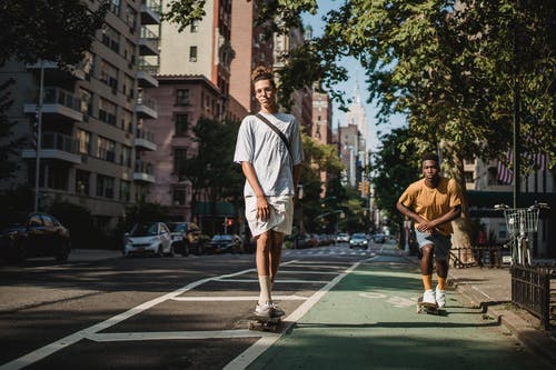 时尚的年轻多民族男子在城市街道上骑滑板 · 免费素材图片