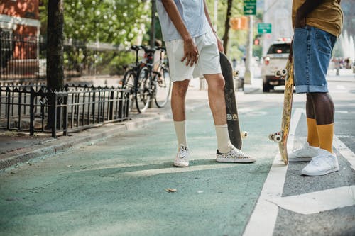 滑板后街上聊天的匿名时尚男性朋友 · 免费素材图片