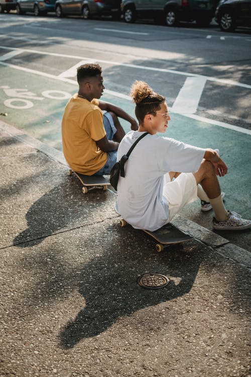骑自行车后在路边休息的时尚年轻多样男性溜冰者 · 免费素材图片