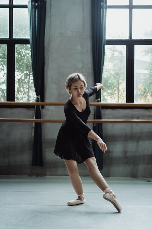 迷人的亚洲芭蕾舞演员在工作室表演舞蹈 · 免费素材图片