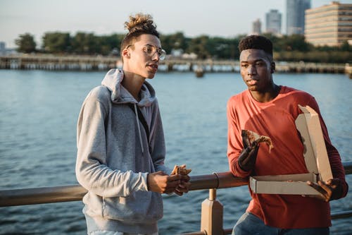 不同的人在城市路堤上吃披萨 · 免费素材图片