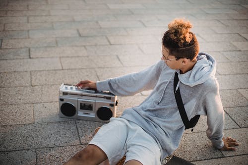 时髦的年轻族裔小伙子，听听音乐与街上的音箱 · 免费素材图片