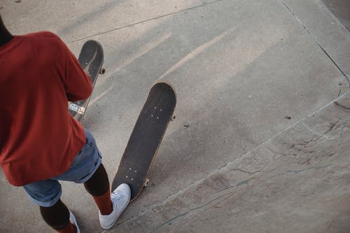 站在大街上的柏油马路上的非洲裔美国溜冰者 · 免费素材图片