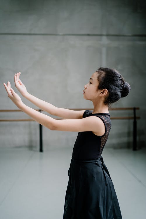 亚洲芭蕾舞女孩在芭蕾课上慷慨地举起手臂 · 免费素材图片