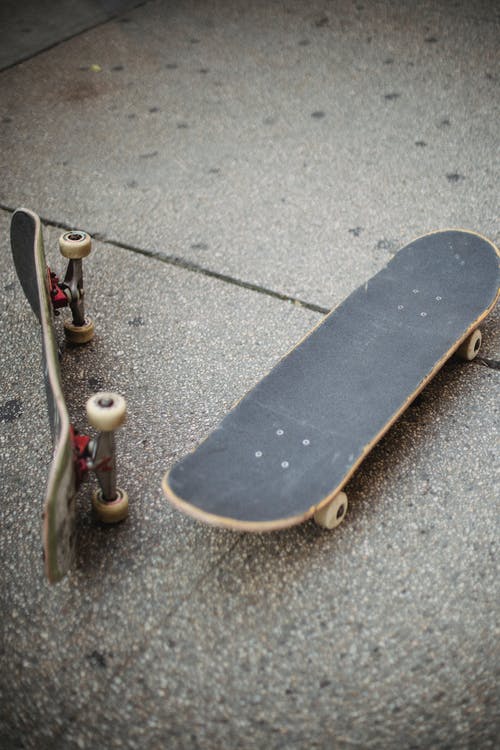 滑板放在街道铺成的道路上 · 免费素材图片