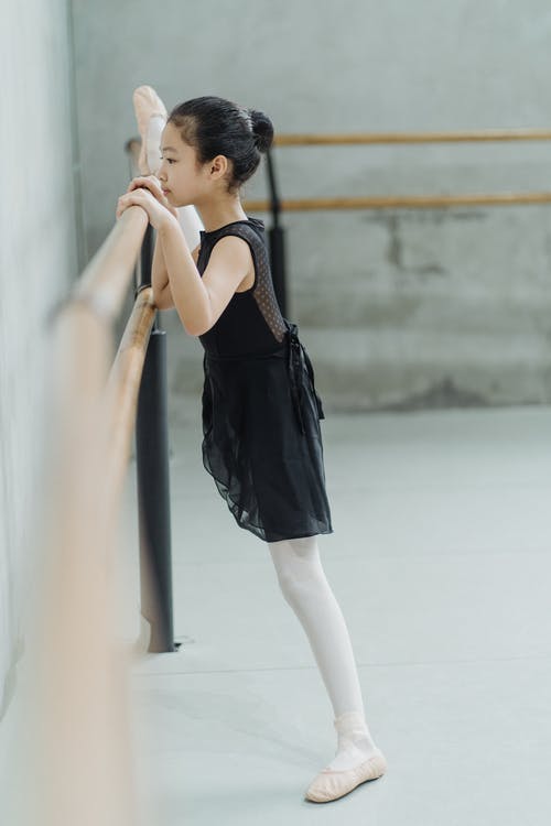 在芭蕾课上伸展在巴利的民族女孩的腿 · 免费素材图片