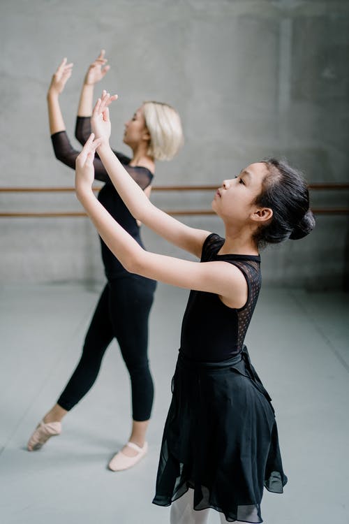 亚洲芭蕾舞演员与双臂上举表演舞蹈 · 免费素材图片