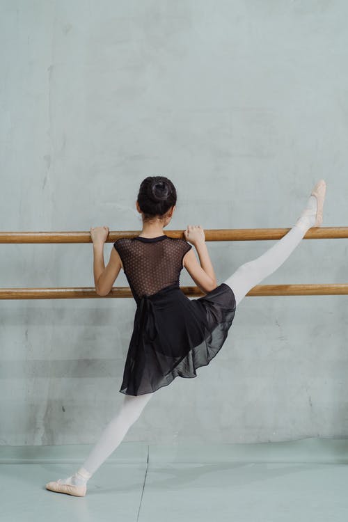 小芭蕾舞演员在巴利上伸展双腿 · 免费素材图片