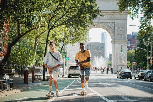 活跃的多样的朋友，在城市的街道上骑滑板 · 免费素材图片