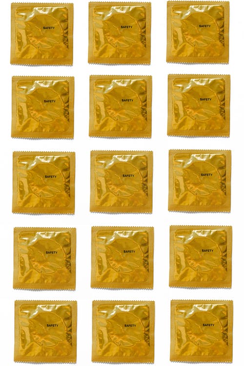 白色背景上的黄色避孕套 · 免费素材图片